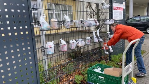 Natalia Wollbaum bestückt den Sozialen Zaun in Bruchsal mit den Spenden.