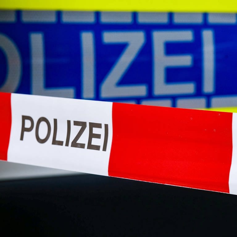 Absperrband vor einem Polizeiauto. Ein unbekannter Mann hat am frühen Mittwochmorgen eine Arztpraxis in Ulm überfallen.