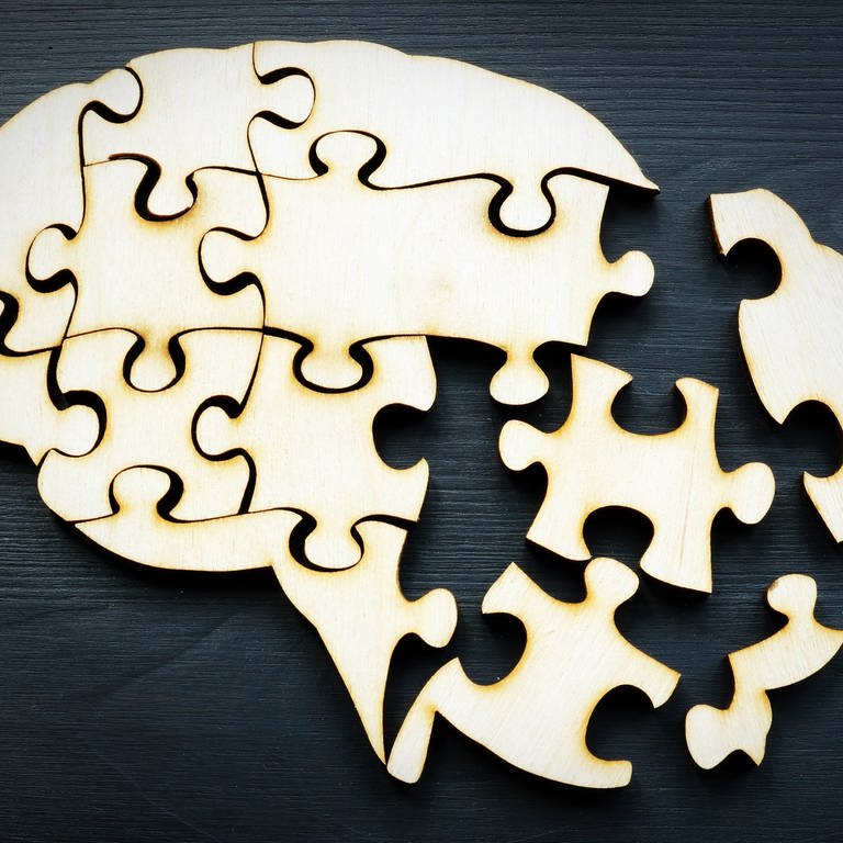 Eine Gehirnform aus Puzzles als Symbol für psychische Gesundheit und Gedächtnisprobleme.
