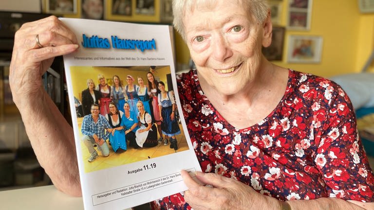Seniorin Jutta mit ihrem Hausreport-Magazin