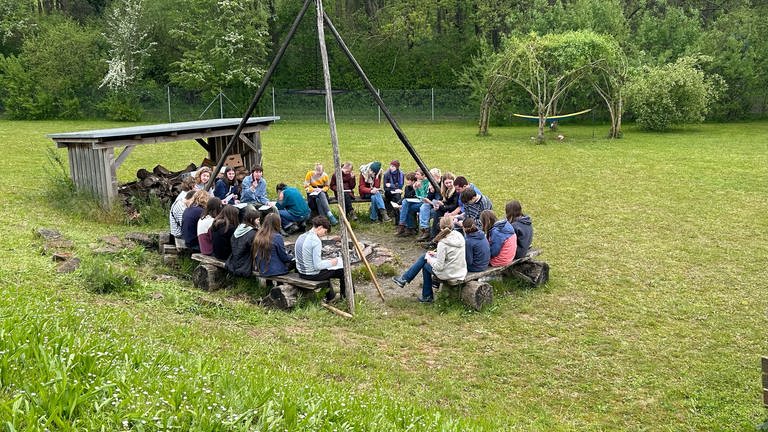 Jugendliche sitzen bei einer Konfi-Freizeit im Kreis