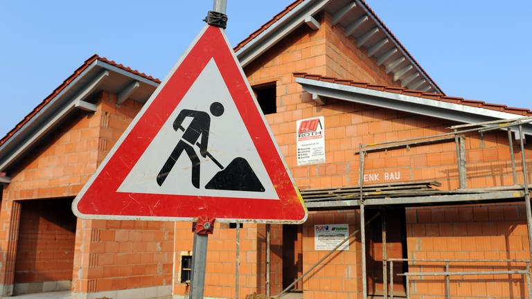 Ein Baustellenschild steht vor dem Rohbau eines Einfamilienhauses in Straubing 
