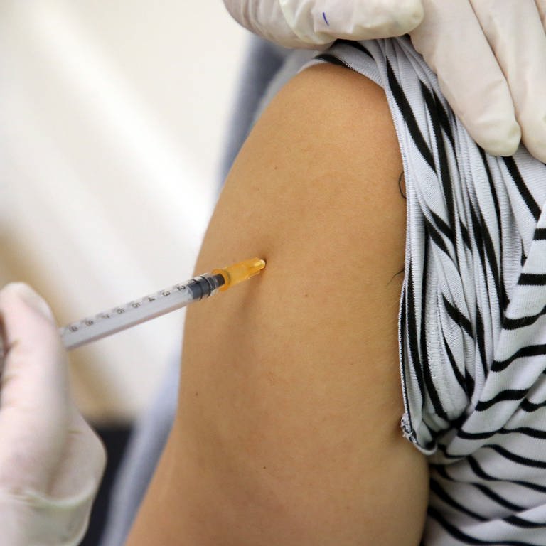 Eine Ärztin impft eine Frau mit einem neuen Corona-Impfstoff. Dieser ist ab Montag in den Arztpraxen verfügbar. (Archivfoto)