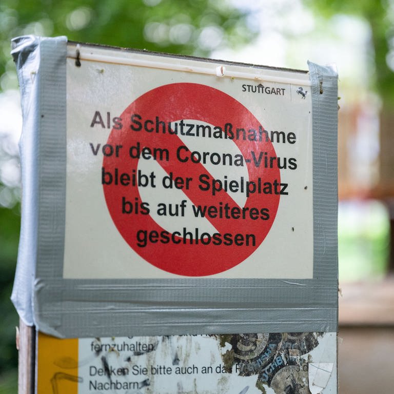 Ein Schild mit der Aufschrift "Als Schutzmaßnahme vor dem Corona-Virus bleibt der Spielplatz bis auf weiteres geschlossen" klebt an einem Schild vor einem Spielplatz in Stuttgart.