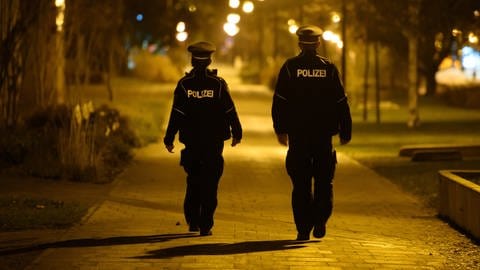 Polizisten laufen in der Nacht Streife und kontrollieren die Einhaltung der Ausgangssperre.