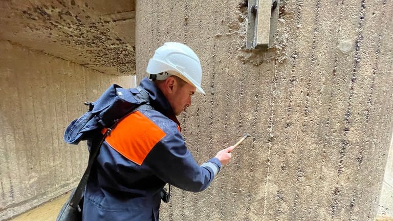 Reparaturarbeiten an der Schleuse Iffezheim: Betonwände der Schleusenkammer werden mit einem Hammer auf Schäden abgeklopft.