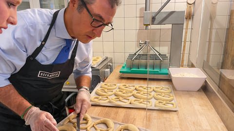 Cem Özdemir, Grüne, Bundesminister für Ernährung und Landwirtschaft, backt Brezeln in der Bäckerei Beckabeck in Bad Urach. (Foto: SWR, Miriam Plappert)
