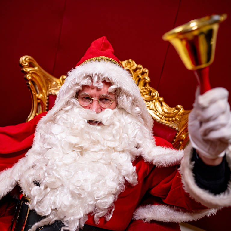 Ein verkleidter Weihnachtsmann klingelt mit einer Glocke