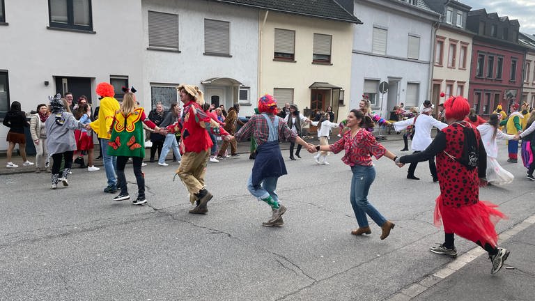 Schärensprung Trier-Biewer: Narren in unterschiedlichen Kostümen hüpfen in Schlangenlinien durch die Straßen.  (Foto: SWR, Martin Schmitt)
