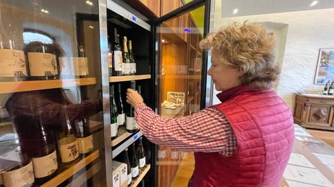Ulrike Boor nimmt für die spezielle Weinprobe einen Riesling aus dem Weinschrank. Im Schrank sind es immer genau 10 Grad.
