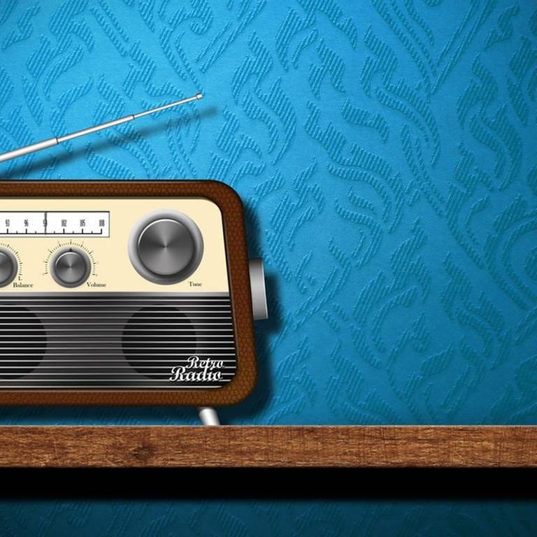 Ein altmodisches Radio mit Antenne steht auf einem Holztisch vor einer blauen Strukturtapete