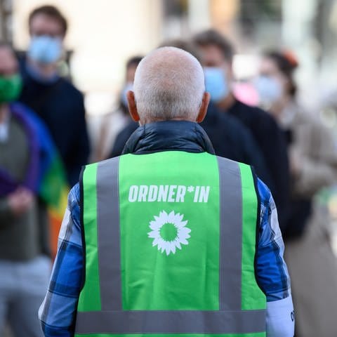Ein Helfer der Wahlkampfveranstaltung von Bündnis 90Die Grünen auf dem Oberkirchplatz trägt während der Veranstaltung am 1.9.2021 eine grüne Warnweste mit gendergerechter Aufschrift "Ordner*in"