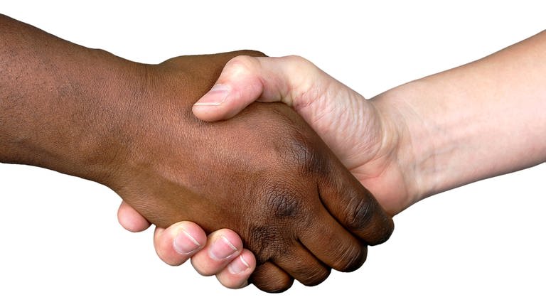 Handschlag einer schwarzen und einer weißen Hand: Menschenrassen gibt es nicht
