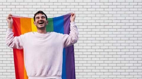 Junger Mann mit Regenbogenflagge: Jugendliche interessieren sich heute sehr für sexuelle Vielfalt und Identität